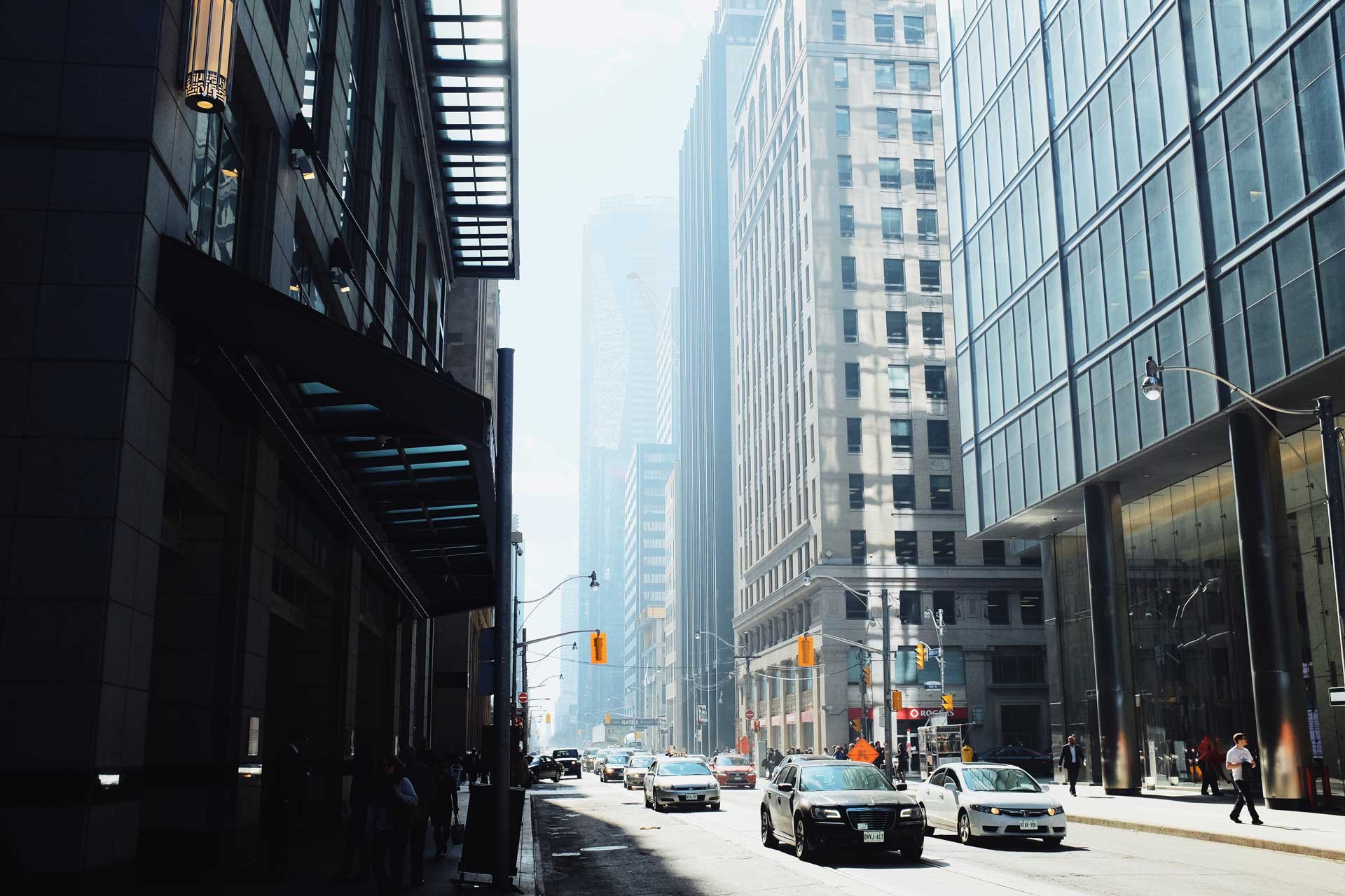 Oncoming traffic at the intersection of Bay St and Adelaide St in Toronto during the day.